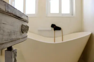 a white bath tub in a room with windows at Luxurious studio apartment close to the beach and airport in Porto Rafti