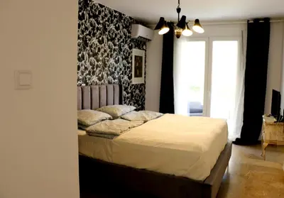 a bedroom with a bed with a black and white wall at Luxurious studio apartment close to the beach and airport in Porto Rafti