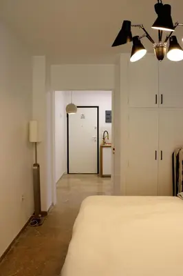 a bedroom with a bed and a hallway with a door at Luxurious studio apartment close to the beach and airport in Porto Rafti