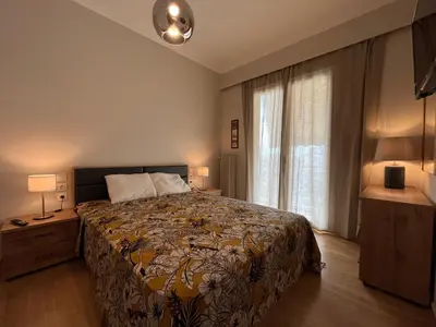 a bedroom with a bed and a large window at Artist's 1 BD Apt in Keramikos in Athens