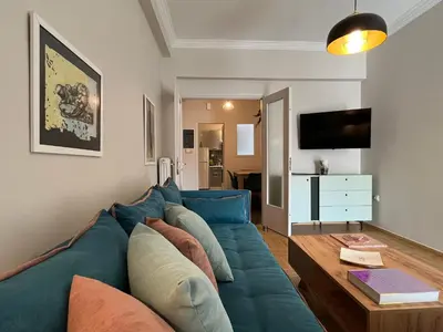 a living room with a blue couch and a table at Artist's 1 BD Apt in Keramikos in Athens
