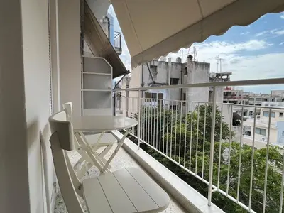 a balcony with a table and a chair and a view at Artist's 1 BD Apt in Keramikos in Athens