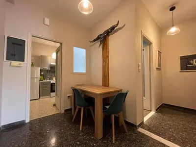 a dining room with a wooden table and green chairs at Artist's 1 BD Apt in Keramikos in Athens
