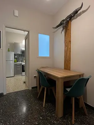a dining room with a wooden table and two chairs at Artist's 1 BD Apt in Keramikos in Athens