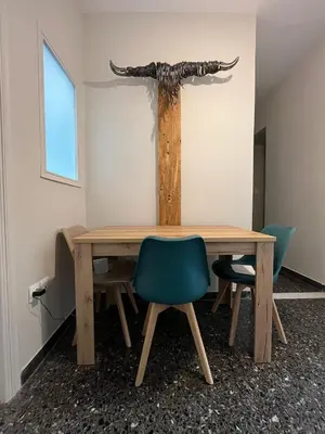 a wooden table with chairs and a tree on the wall at Artist's 1 BD Apt in Keramikos in Athens