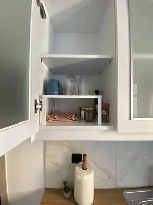 a kitchen shelf with dishes and a bottle in it at Azure Studio in Athens