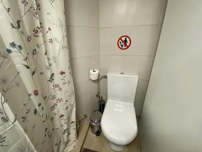 a small bathroom with a toilet and a shower curtain at Azure Studio in Athens