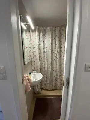 a bathroom with a sink and a shower curtain at Azure Studio in Athens