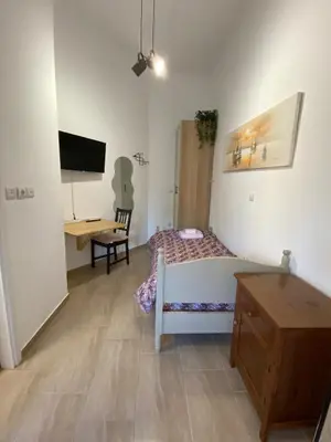 a bedroom with a bed and a desk and a tv at Azure Studio in Athens