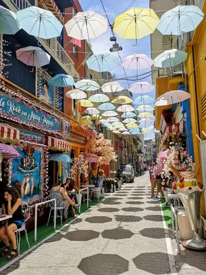 an alley with umbrellas hanging over a street at DIONE Luxury Business Suite in the heart of Athens in Athens