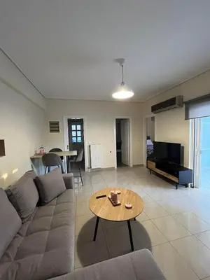 a living room with a couch and a table at Spata Airside Apartment in Spáta