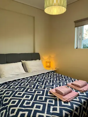 a bedroom with a bed with towels on it at Spata Airside Apartment in Spáta