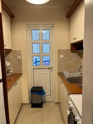 a small kitchen with a door and a window at Spata Airside Apartment in Spáta