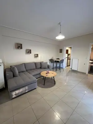 a living room with a couch and a table at Spata Airside Apartment in Spáta
