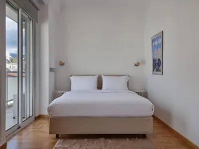 a bedroom with a bed and a large window at Parthenon Panorama 3bd in Athens