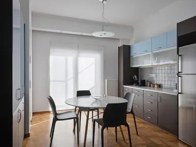 a kitchen with a dining room table and chairs at Parthenon Panorama 3bd in Athens