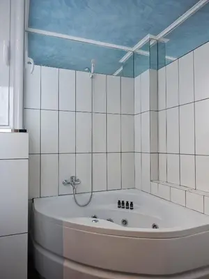 a bath tub in a bathroom with a mirror at Parthenon Panorama 3bd in Athens
