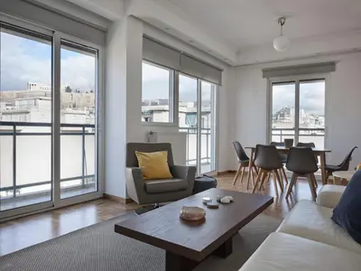 a living room with a couch and a table at Parthenon Panorama 3bd in Athens