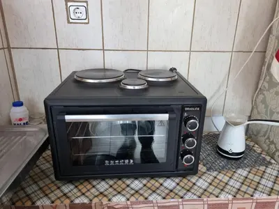 a black toaster oven sitting on top of a counter at DianaBNB in Artemida