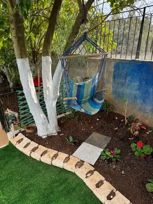 a garden with a hammock hanging from a tree at DianaBNB in Artemida