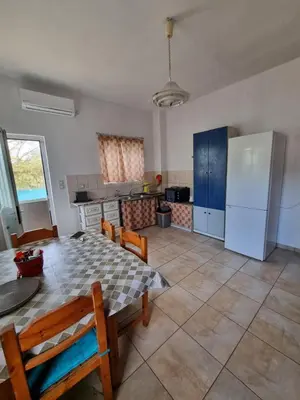 a kitchen with a table and chairs and a refrigerator at DianaBNB in Artemida