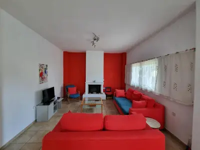 a living room with red walls and a red couch at DianaBNB in Artemida