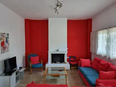 a living room with red walls and a blue couch at DianaBNB in Artemida
