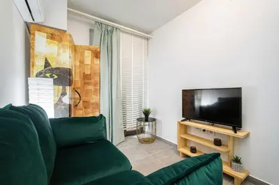 a living room with a green couch and a flat screen tv at modern boutique apartment in Athens