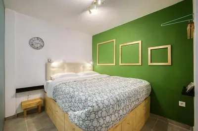 a bedroom with a bed with a green wall at modern boutique apartment in Athens