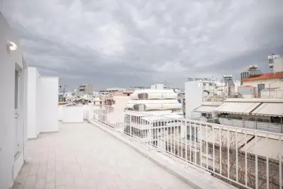 a balcony with white fences and white buildings at Spacious Penthouse near Downtown in Athens