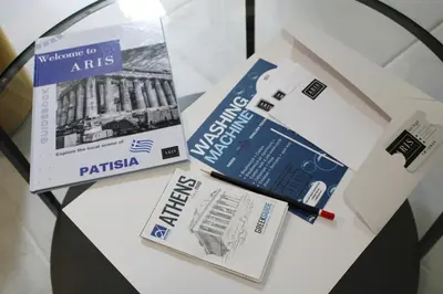 a table with two pamphlets and a book on it at ARIS Patisia in Athens