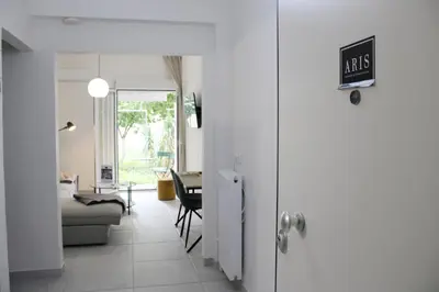 a white hallway with a living room and a table at ARIS Patisia in Athens