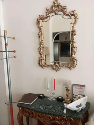 a mirror on a wall above a table with a candle at Κατερινα in Athens