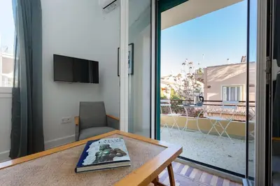 a table with a book on it in a room with a balcony at Troon of Athens House in Athens