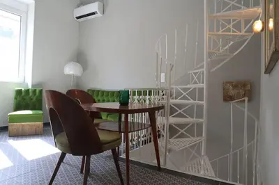 a dining room with a table and a staircase at Troon of Athens House in Athens