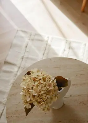 a white vase filled with flowers on a table at Urban Athéna Apartment,Pangrati in Athens
