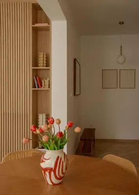 a vase with red flowers sitting on a table at Urban Athéna Apartment,Pangrati in Athens
