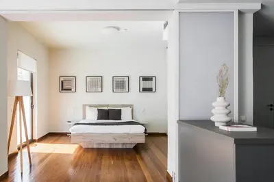 a bedroom with a bed and a white wall at The Hill by Zoia Living in Athens