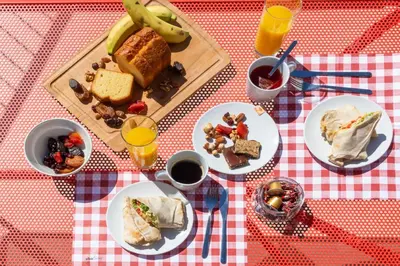 a table with plates of food on a red and white checked table cloth at The Hill by Zoia Living in Athens