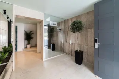a hallway with a wooden wall with plants and a door at The Hill by Zoia Living in Athens