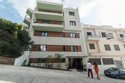 a man and a woman walking in front of a building at The Hill by Zoia Living in Athens