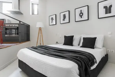 a bedroom with a large bed with black and white sheets at The Hill by Zoia Living in Athens