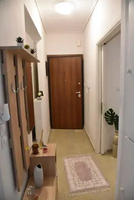 a hallway with a wooden door and a room with a rug at Citrus dream apartment in Athens