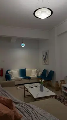 a living room with a couch and blue chairs at Citrus dream apartment in Athens