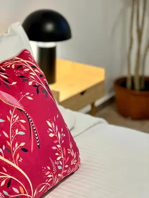 a red pillow sitting on top of a bed at Centrum Athens Apt. in Athens