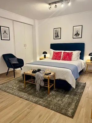 a bedroom with a bed with red pillows and a table at Centrum Athens Apt. in Athens