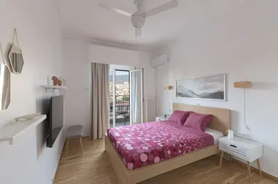a bedroom with a bed with purple sheets and a tv at Sunny Central Luxury 50 sm with balcony view 4th floor in Athens