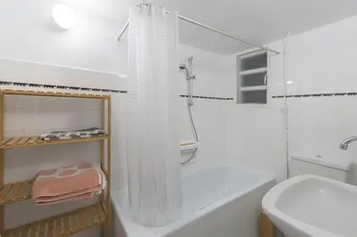 a white bathroom with a tub and a toilet and a sink at Sunny Central Luxury 50 sm with balcony view 4th floor in Athens