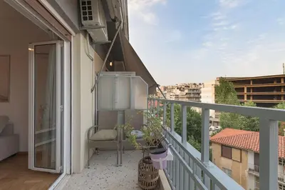 a balcony with a chair on top of a building at Sunny Central Luxury 50 sm with balcony view 4th floor in Athens