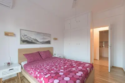 a bedroom with a bed with a pink comforter at Sunny Central Luxury 50 sm with balcony view 4th floor in Athens
